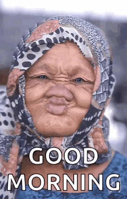 an elderly woman wearing a scarf on her head is making a funny face and says `` good morning '' .
