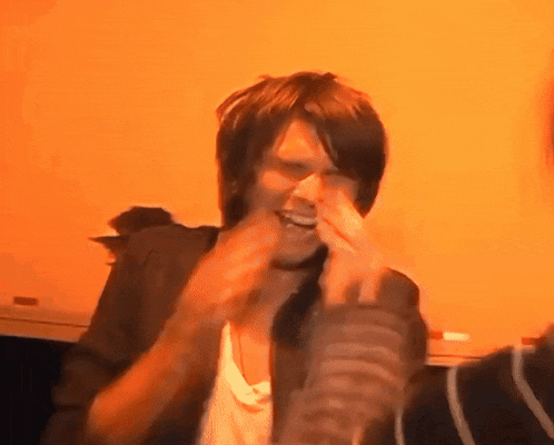 a man covering his face with his hands and smiling