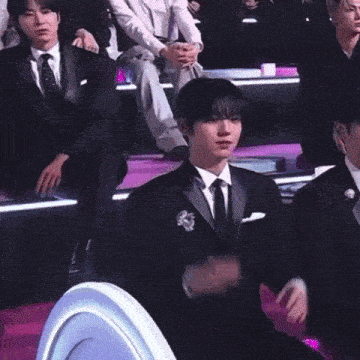 a man in a suit and tie is giving a middle finger