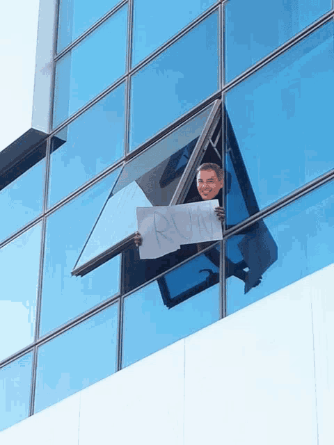 a man holds a sign that says run in front of a building