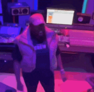 a man is dancing in a room with purple lights and a shirt that says claire