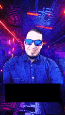 a man wearing sunglasses and a blue shirt is taking a selfie in a dark room