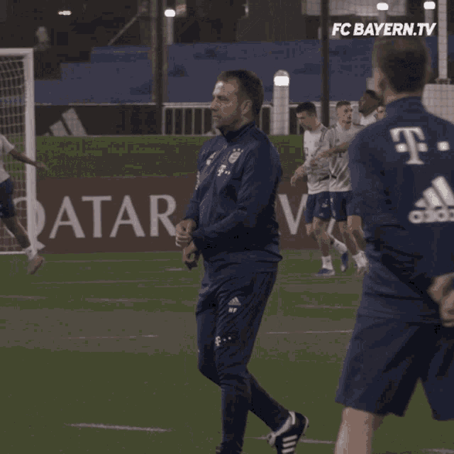 a group of soccer players are on a field with an ad for qatar behind them