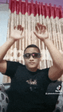 a young man wearing sunglasses and a black shirt with the word nike on the front