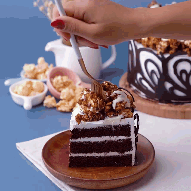a piece of chocolate cake with popcorn on top is being eaten with a fork