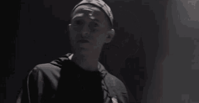 a man is singing into a microphone in a dark room while wearing a headband .
