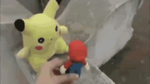 a person is holding a mario toy in front of a street