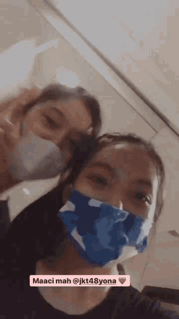 two girls wearing face masks with the name maaci mah @ jkt48yona