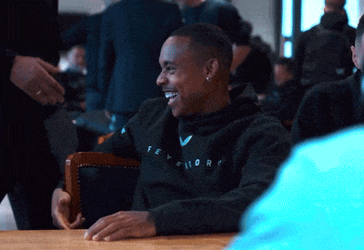 a man wearing a black sweatshirt with the word fever on it smiles