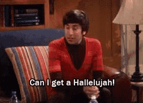 a man in a red shirt is sitting on a couch and saying can i get a hallelujah .
