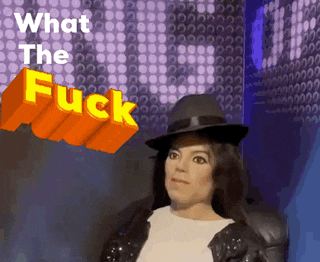 a statue of michael jackson stands in front of a wall with the words " what the fuck " on it