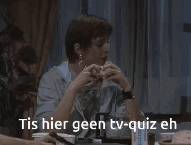 a man sitting at a table with the words tis hier geen tv-quiz eh on the bottom