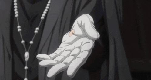 a person wearing a white glove and a rosary necklace holds something in their hand