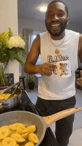 a man wearing a flames shirt is holding a mug