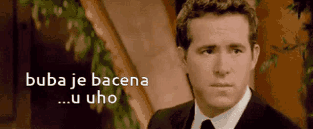 a man in a suit and tie with the words buba je bacena u uho below him