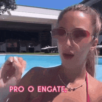 a woman wearing sunglasses and a red bikini is standing in front of a pool