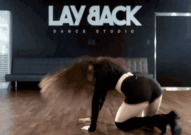 a woman dancing in front of a lay back dance studio