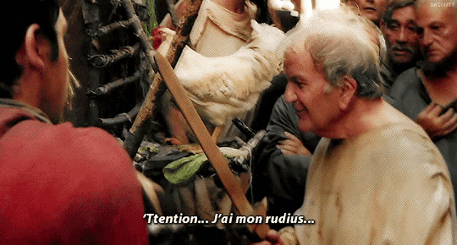 a man in a crowd is talking to another man and says " ttention "