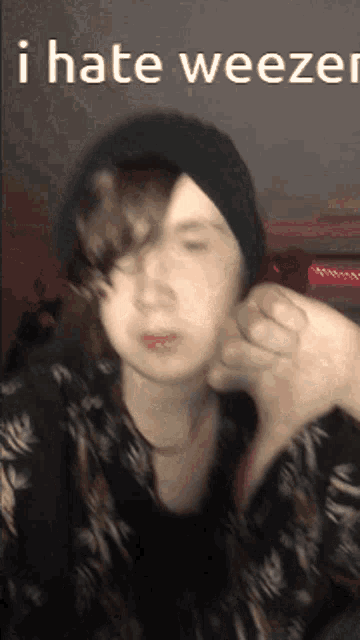 a person giving a thumbs down with the words i hate weezer on the bottom right