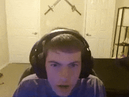 a young man wearing headphones looks at the camera with two swords on the wall behind him
