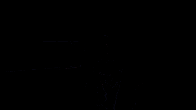 a man wearing a shirt that says wolves stands in a dark room