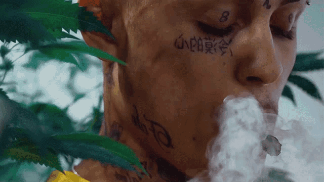a man with chinese writing on his face is smoking