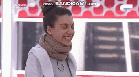 a woman wearing a scarf around her neck is laughing .