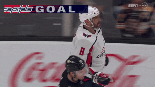 a hockey player with the number 8 on his jersey is celebrating a goal