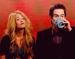a man and a woman are drinking from a blue cup