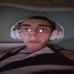 a man wearing headphones and glasses making a funny face