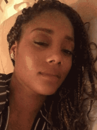 a close up of a woman 's face with braids