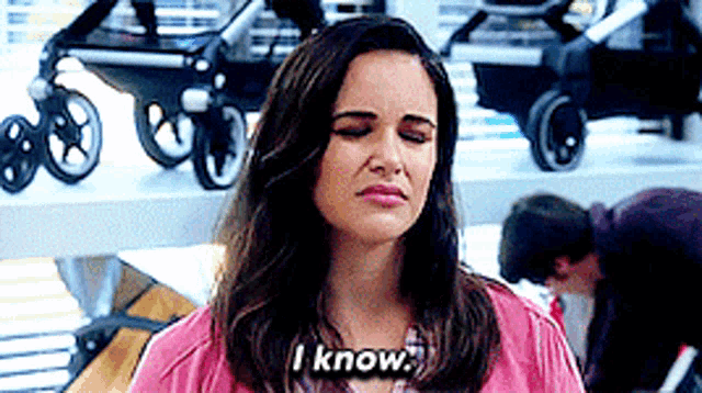 a woman says " i know " in front of a display of baby strollers
