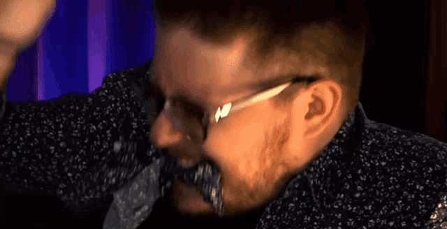 a man with glasses and a beard is making a face .