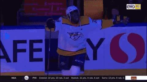 a hockey player holding a stick on the ice with a fox advertisement behind him