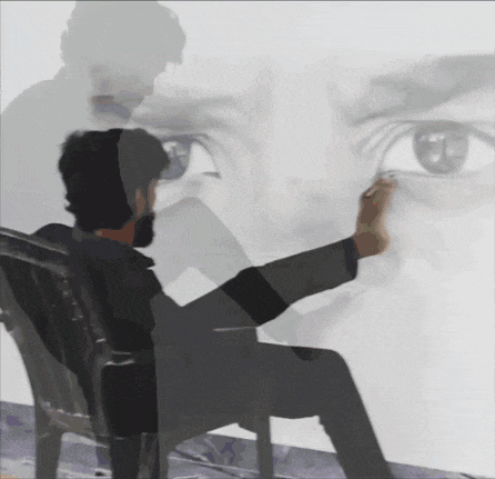 a man sits in a chair with his feet up in front of a painting of a man 's eyes