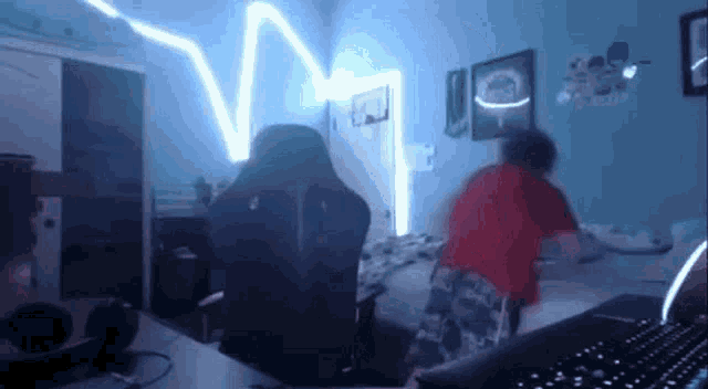 a person is standing on a bed in a room with a keyboard and chair .