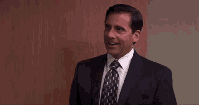 a man in a suit and tie is smiling in front of a door .