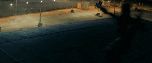 a person standing on a concrete surface in a dark area