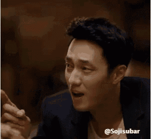 a man in a suit is making a funny face and giving the middle finger .
