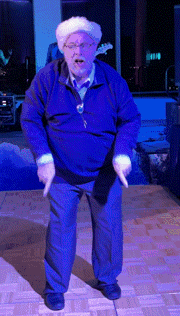 a man in a blue jacket is dancing in front of a blue background