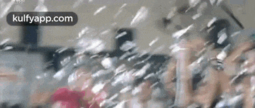 a group of people are sitting in a room with bubbles coming out of the window .