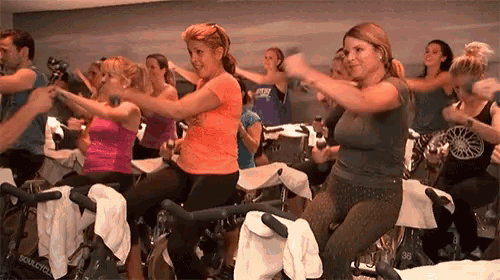 a group of people are riding exercise bikes in a gym and one of them is wearing a shirt that says soulcycle