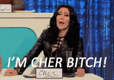 a woman is sitting at a table with a sign that says i 'm cher bitch !