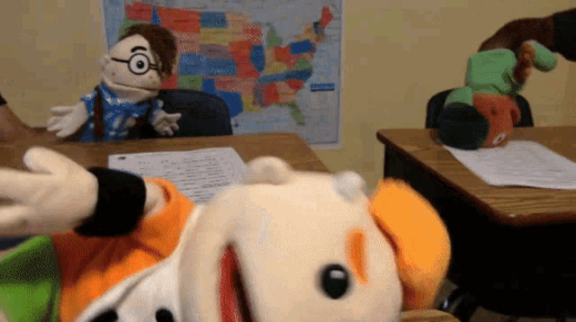 a map of the united states hangs on the wall behind a puppet