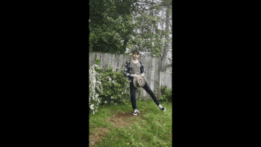 a man in a cowboy hat is standing in the grass