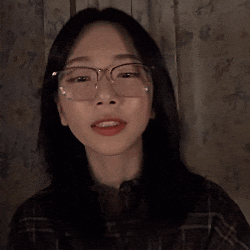 a close up of a woman 's face with glasses and red lips
