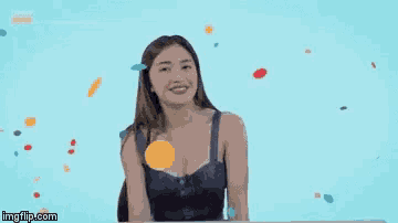 a woman in a blue dress is smiling in front of a blue background