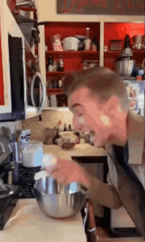 a man is mixing something in a bowl in the kitchen