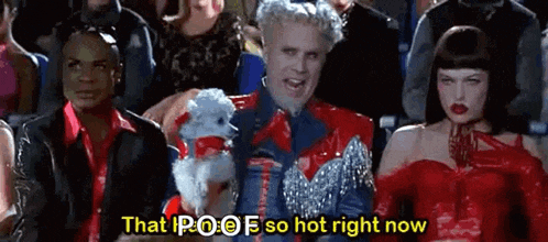 a group of people are sitting in a theater watching a movie and a man is holding a poodle .