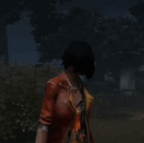 a woman in a red leather jacket is standing in the dark .